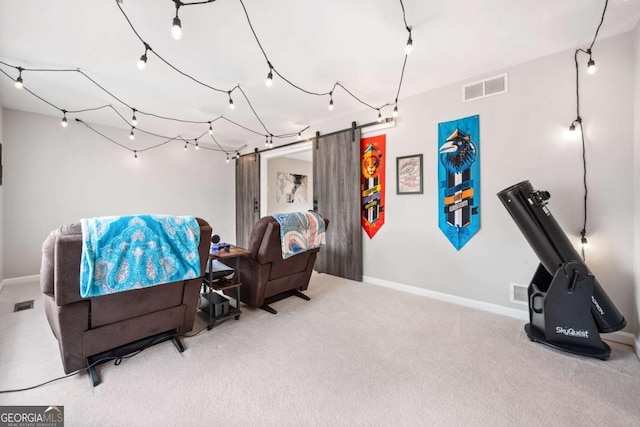 sitting room featuring a barn door, baseboards, visible vents, and carpet floors