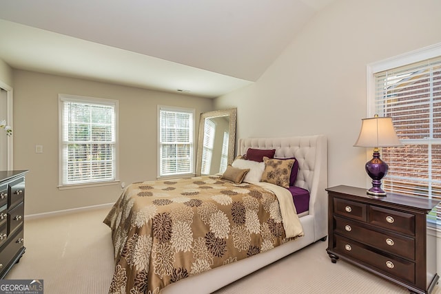 bedroom featuring lofted ceiling, baseboards, visible vents, and light carpet