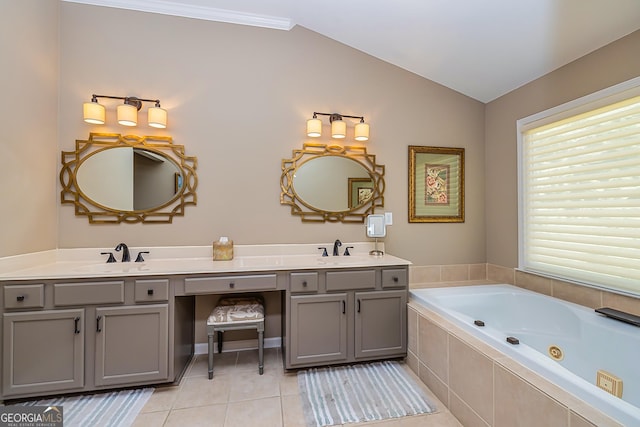 full bath featuring a sink, lofted ceiling, a tub with jets, and tile patterned floors