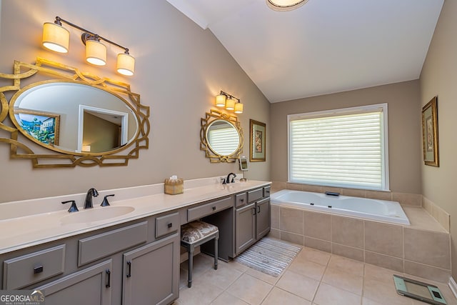 bathroom with tile patterned floors, lofted ceiling, a garden tub, and a sink