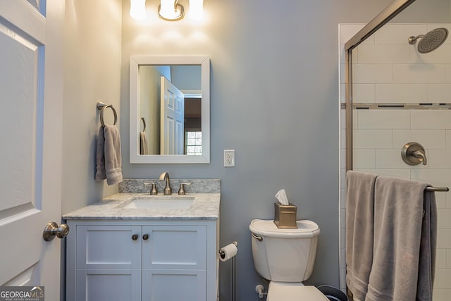 full bath featuring a tile shower, toilet, and vanity