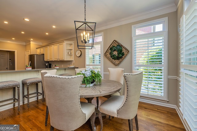 dining area featuring recessed lighting, a notable chandelier, ornamental molding, and dark wood-style flooring