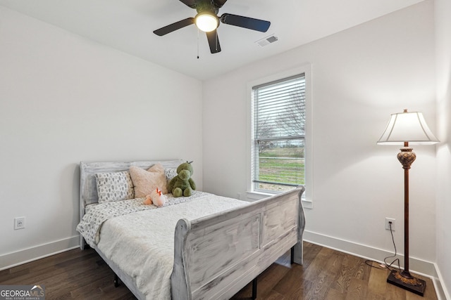 bedroom featuring ceiling fan, visible vents, baseboards, and wood finished floors