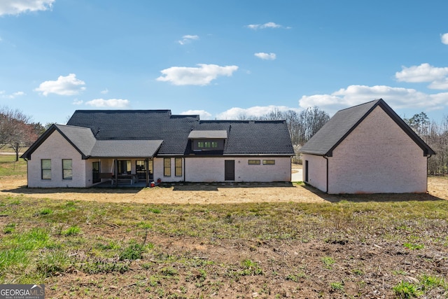 rear view of house with a lawn and brick siding