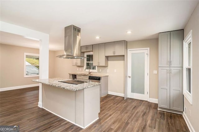 kitchen featuring dark wood-style flooring, gray cabinets, island exhaust hood, and a sink