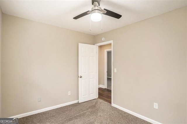 carpeted empty room featuring ceiling fan and baseboards