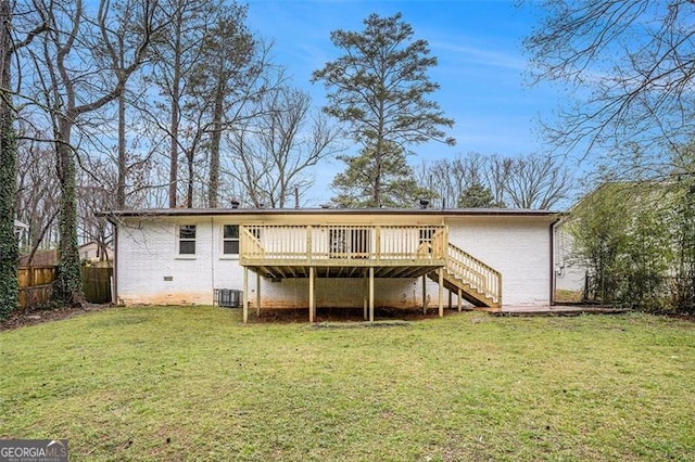 back of house featuring brick siding, stairway, a wooden deck, and a yard