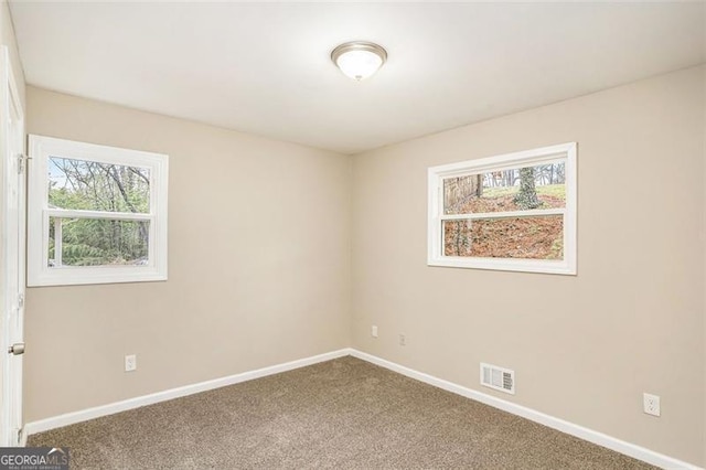 empty room with visible vents, baseboards, and carpet