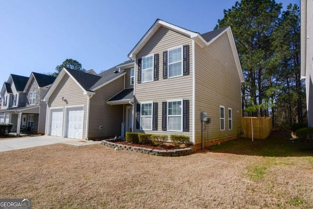 traditional-style house with concrete driveway, an attached garage, and a front yard