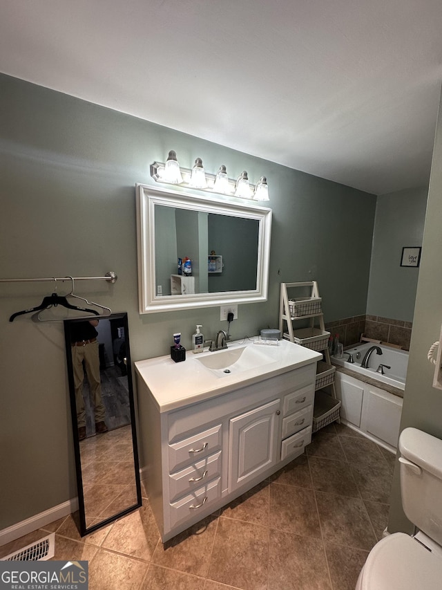 bathroom with visible vents, tile patterned floors, toilet, a bath, and vanity