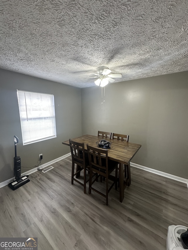 dining space featuring baseboards, a textured ceiling, wood finished floors, and a ceiling fan