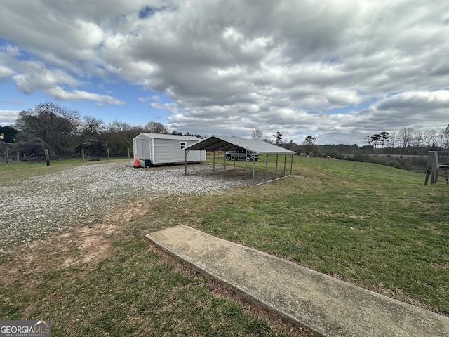 view of yard featuring a storage unit, an outbuilding, and a detached carport