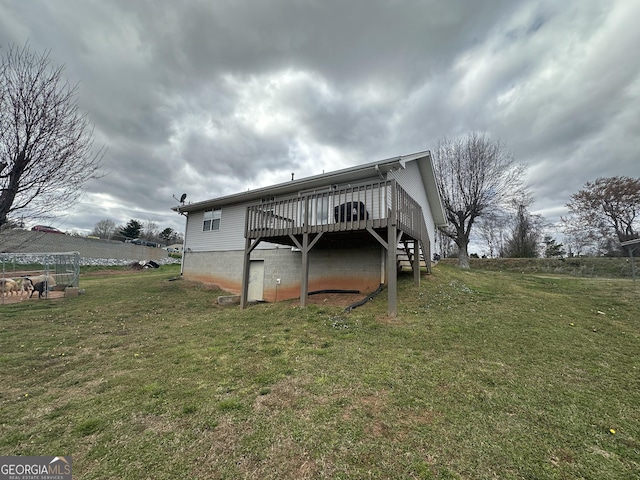 back of property featuring stairs, a lawn, and a wooden deck