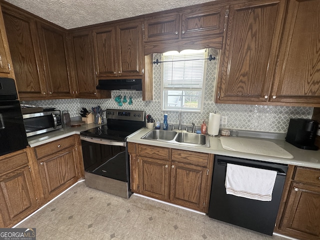 kitchen with a sink, decorative backsplash, light countertops, stainless steel appliances, and under cabinet range hood