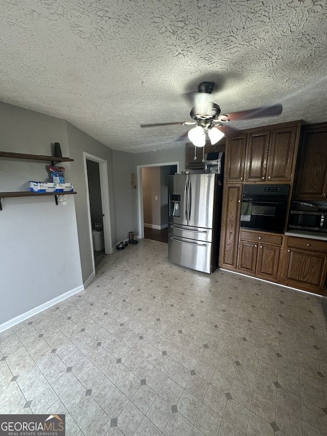 kitchen with light floors, baseboards, ceiling fan, stainless steel refrigerator with ice dispenser, and black oven