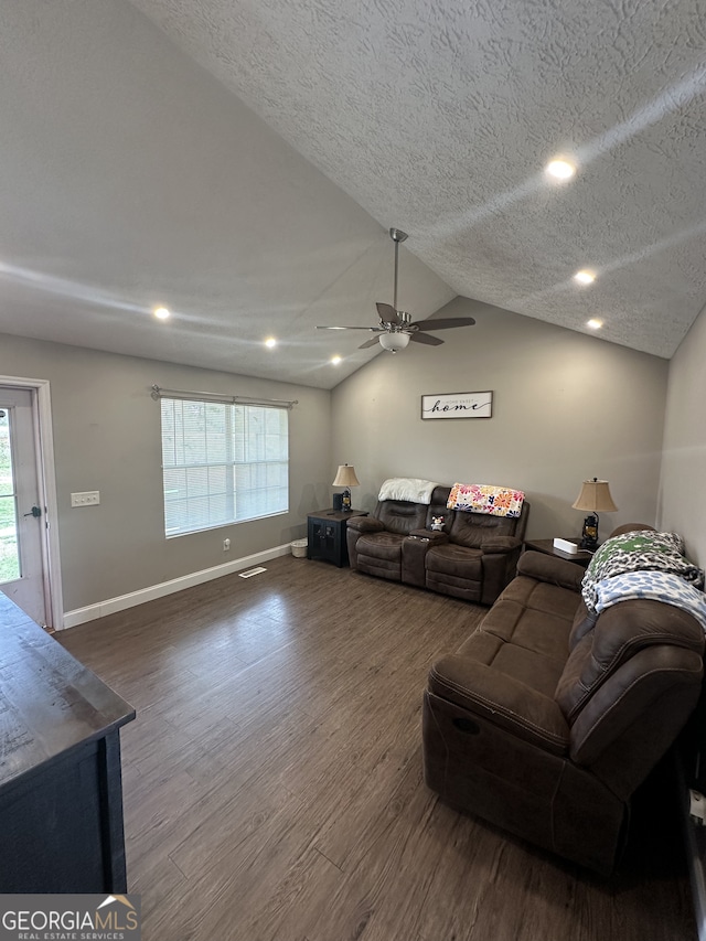 living room featuring ceiling fan, baseboards, dark wood finished floors, lofted ceiling, and a textured ceiling