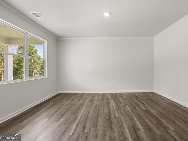 empty room with visible vents, baseboards, dark wood-type flooring, and ornamental molding