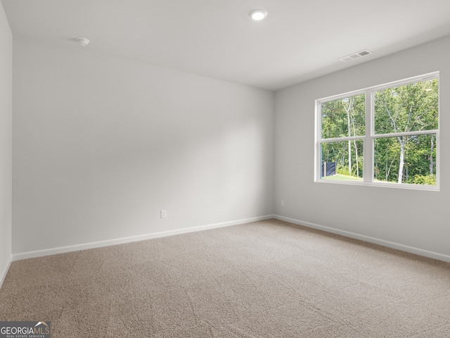 spare room with visible vents, baseboards, and carpet