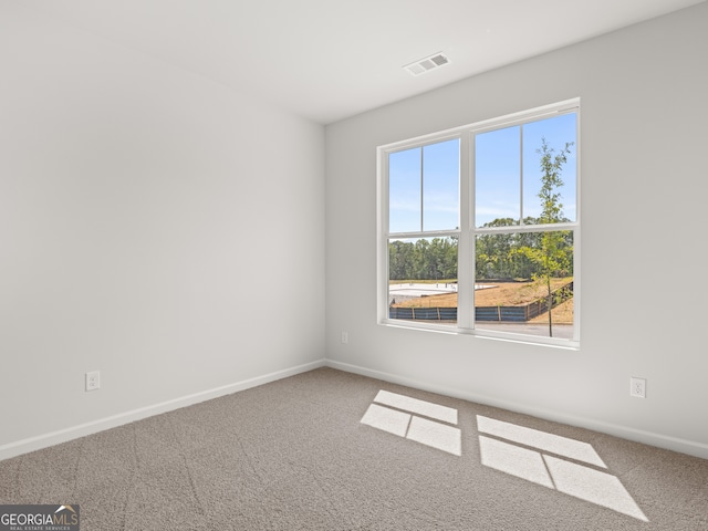 carpeted spare room with baseboards and visible vents