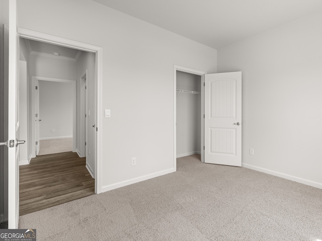 unfurnished bedroom featuring a closet, baseboards, and carpet floors