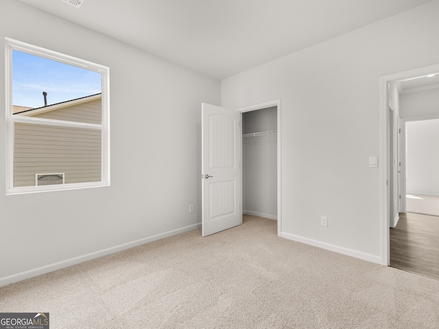 unfurnished bedroom featuring a closet, baseboards, and carpet flooring