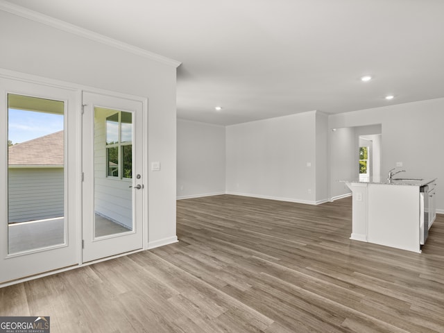 empty room with recessed lighting, baseboards, wood finished floors, and ornamental molding