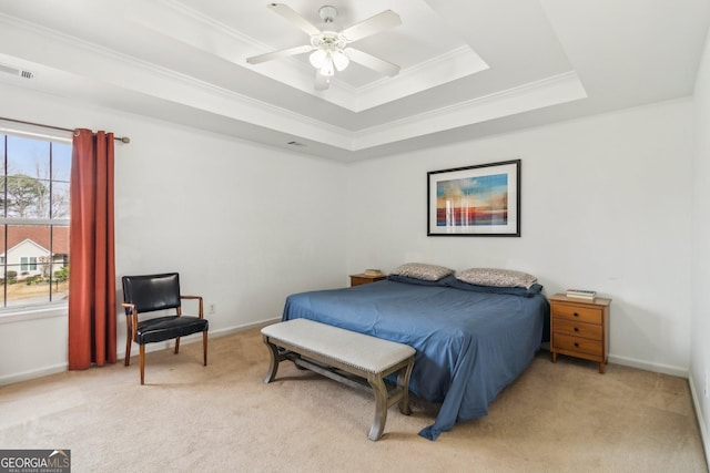 bedroom with visible vents, ornamental molding, a tray ceiling, baseboards, and light colored carpet