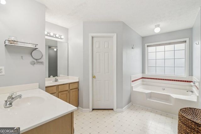 full bath featuring a sink, a textured ceiling, and tile patterned floors