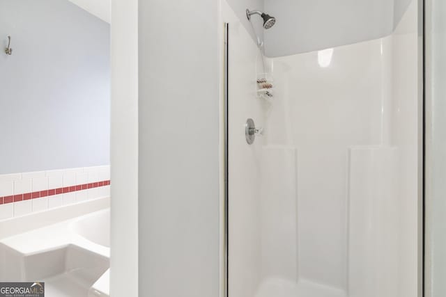 bathroom featuring a bath and a shower stall