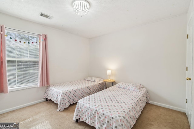 carpeted bedroom featuring visible vents and baseboards