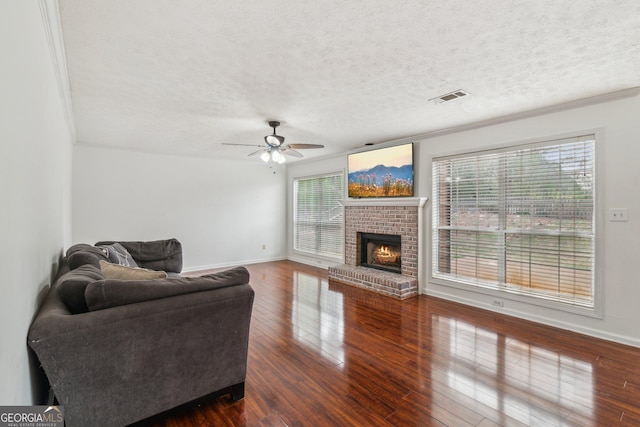 living room featuring ceiling fan, visible vents, plenty of natural light, and dark wood-style floors