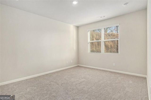 spare room featuring visible vents, baseboards, and carpet