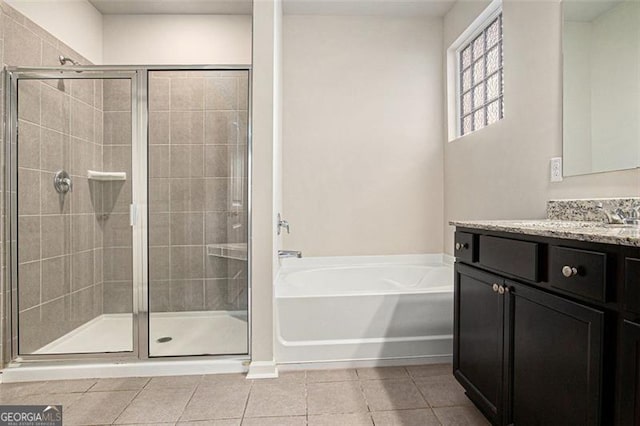 bathroom with a bath, tile patterned flooring, a shower stall, and vanity