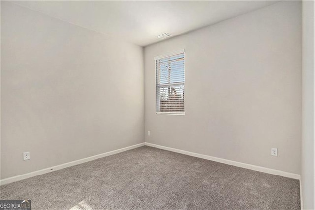 unfurnished room with carpet flooring, baseboards, and visible vents