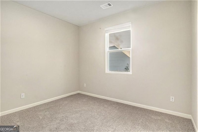 spare room with visible vents, baseboards, and carpet