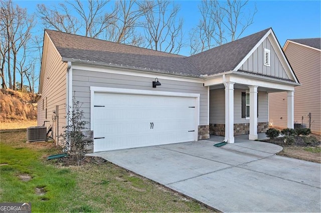 view of front of home with central air condition unit, driveway, stone siding, a porch, and a garage