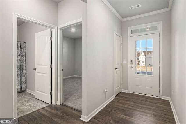 foyer entrance with dark wood finished floors, crown molding, baseboards, and visible vents