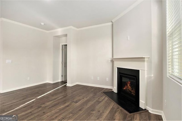 unfurnished living room with a glass covered fireplace, crown molding, dark wood finished floors, and baseboards