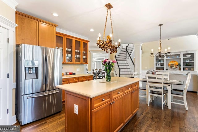 kitchen featuring stainless steel fridge, a notable chandelier, and brown cabinetry