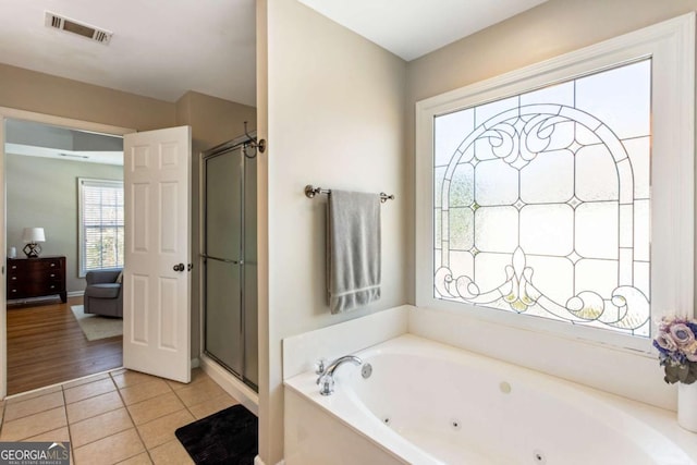 bathroom featuring tile patterned floors, a tub with jets, visible vents, and a shower stall