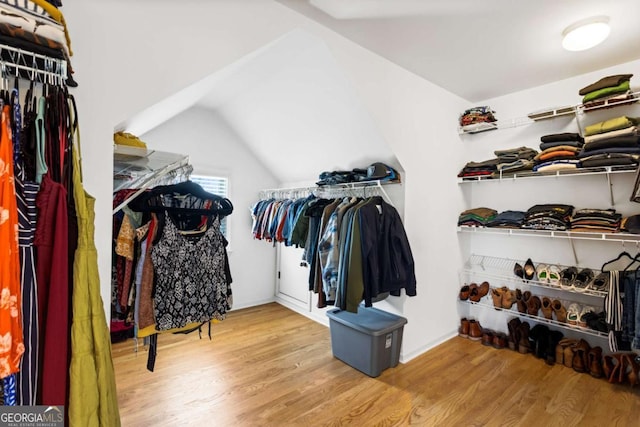 walk in closet with vaulted ceiling and wood finished floors