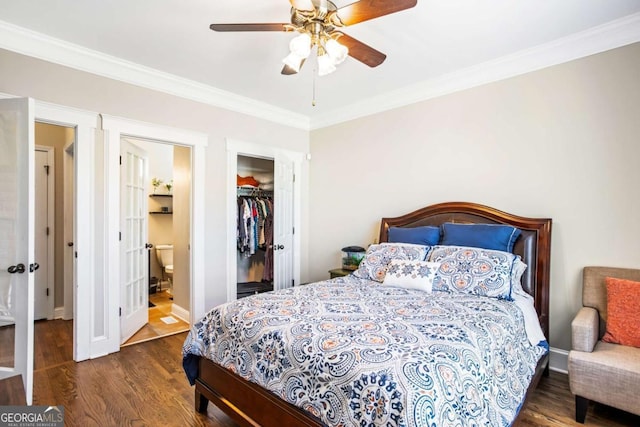 bedroom featuring wood finished floors, baseboards, ornamental molding, a closet, and ensuite bathroom