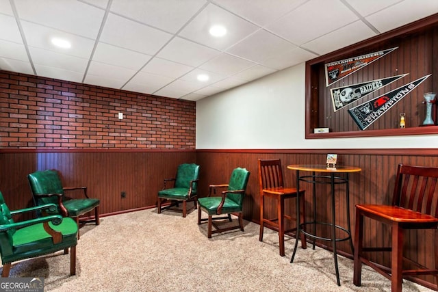 sitting room with a wainscoted wall, a paneled ceiling, a dry bar, and carpet flooring