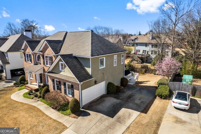 view of property exterior with driveway, fence, brick siding, and a residential view