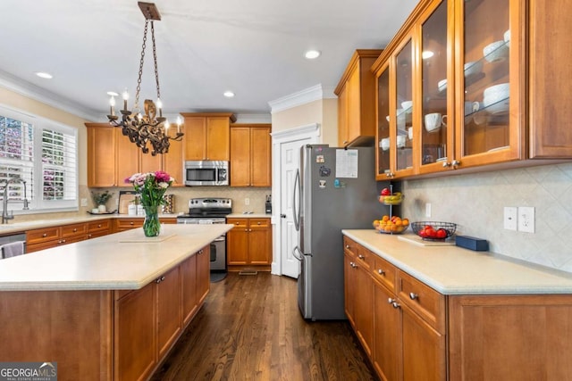 kitchen featuring tasteful backsplash, dark wood finished floors, light countertops, appliances with stainless steel finishes, and brown cabinetry