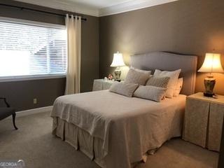 bedroom featuring carpet flooring, baseboards, and ornamental molding