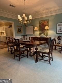 dining area featuring a notable chandelier, visible vents, light carpet, and crown molding