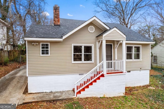 bungalow featuring crawl space, fence, a chimney, and a shingled roof