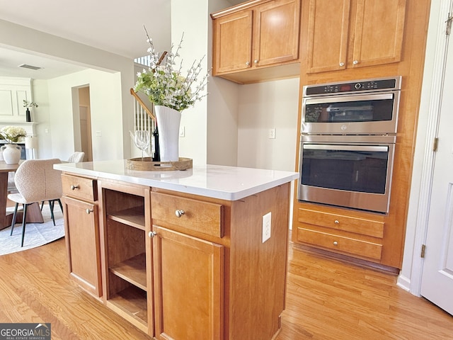 unfurnished living room featuring visible vents, baseboards, and wood finished floors