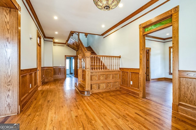 stairway featuring a wainscoted wall, recessed lighting, ornamental molding, and wood finished floors